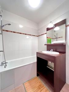 a bathroom with a sink and a bath tub at Appartement DisneyLand Paris in Montévrain