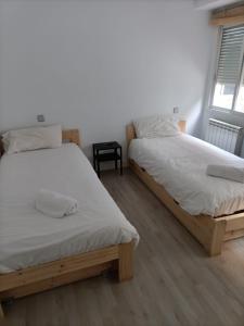 1 dormitorio con 2 camas y ventana en Príncipe habitaciones en Madrid