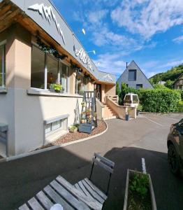 un bâtiment avec un banc dans un parking dans l'établissement Alti'Pic Hôtel, à Le Mont-Dore