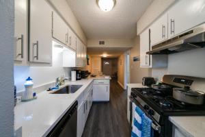 a kitchen with white cabinets and a stove top oven at Austin - Down by the Sea - 1 br Apt near SoCo in Austin