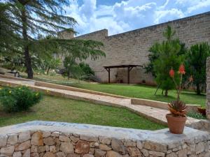 einen Garten mit einer Steinmauer und einem Pavillon in der Unterkunft Villetta Crumisi in Sannicola
