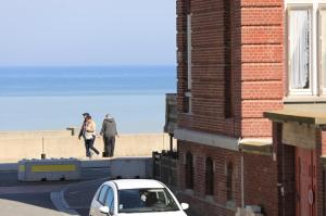 un paio di persone che camminano sulla spiaggia con un'auto di laureclipse2 a Mers-les-Bains