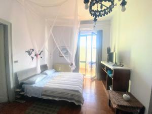 um quarto com uma cama, uma secretária e uma janela em Teocle Beach rooms em Giardini Naxos