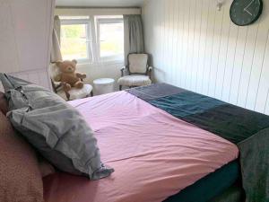 a bedroom with a bed with a teddy bear in a chair at Dobbeltrom in Moss