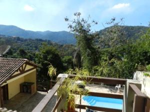 a house with a swimming pool and mountains in the background at Penedo Flats in Penedo