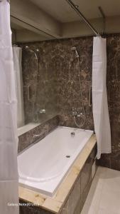 a bathroom with a shower and a white bath tub at Suite Roma 1 at Royal Spa in Velingrad