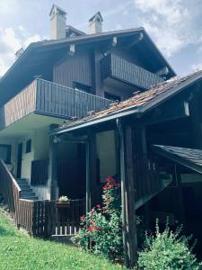 una casa con porche, escaleras y flores en mansardacourmayeur, en Courmayeur