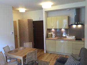 a kitchen and dining room with a table and chairs at Apartament z Tarasem in Świnoujście