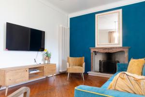 a living room with a tv and a blue wall at Palazzo Branca - Unique experience in Brissago