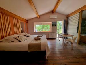 a bedroom with a bed and a table and a window at Villa Alyzea in Bessan +39 photos
