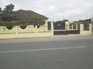 Ein gelber Zaun mit Pflanzen an einer Straße in der Unterkunft Accra Service Villas- 3 in Spintex