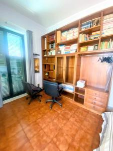 una oficina con dos sillas y un escritorio y estanterías de libros en Teocle Beach rooms, en Giardini Naxos