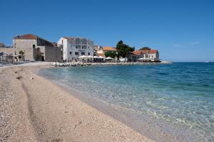 a sandy beach with houses and the ocean at Apartment Primero in Primošten