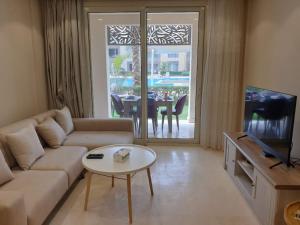 - un salon avec un canapé et une table dans l'établissement Mangroovy - Delicate 1BR Ground floor by the Pool, à Hurghada