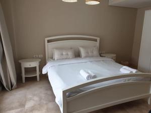 - une chambre avec un lit blanc et 2 tables dans l'établissement Mangroovy - Delicate 1BR Ground floor by the Pool, à Hurghada