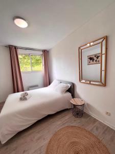 a bedroom with a large white bed and a mirror at Appartement 10 MIN de Disneyland Paris in Montévrain