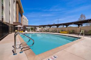 - une grande piscine avec une main courante en métal à côté d'un bâtiment dans l'établissement Home2 Suites By Hilton Petaluma, à Petaluma