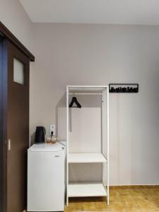 a white refrigerator and a shelf in a room at Grecos ZERO SKIATHOS in Skiathos +29 photos