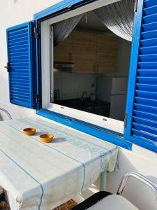 a table with two bowls on it with a window at Blue relax house in Punta Mujeres