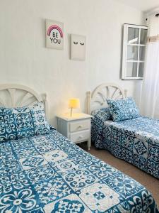 a bedroom with two beds with blue and white sheets at Blue relax house in Punta Mujeres