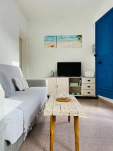 a bedroom with a bed and a table with a tv at Blue relax house in Punta Mujeres
