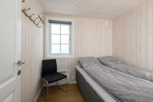 a bedroom with a bed and a chair in it at Holiday home in beautiful Sjusjøen, near Lillehammer in Ringsaker