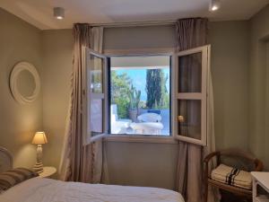 a bedroom with a window with a view of a patio at EXQUISITE GOLF VILLA with Sea, 8Tee, Green Views, in Aphrodite Hills Golf Resort in Kouklia