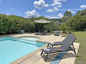 a pool with a chair and an umbrella next to it at Mas Benoit in Salernes