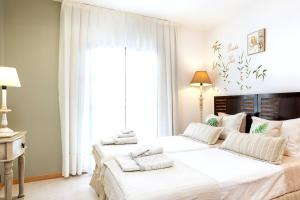a bedroom with two beds with white sheets and a window at The Paradise suites by ANNE, Cozy apartment in Adeje in Adeje +44 photos