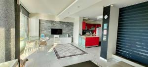 a kitchen with red cabinets and a tv in a room at Amazing Seaview Flat in Kuşadası