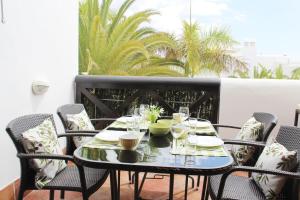 a table with glasses and plates on a balcony at The Paradise suites by ANNE, Cozy apartment in Adeje in Adeje