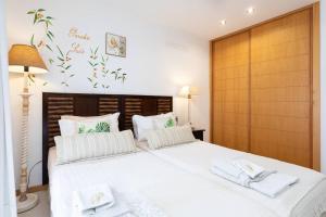 a bedroom with a large white bed with towels on it at The Paradise suites by ANNE, Cozy apartment in Adeje in Adeje