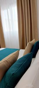 1 cama con 3 almohadas y ventana en Novalis Rooms, en Porto Cesareo