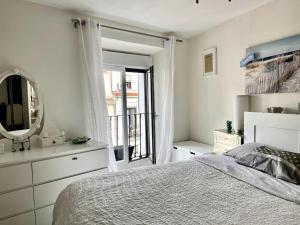 ein weißes Schlafzimmer mit einem Bett und einem Spiegel in der Unterkunft OPERA DELUXE - CENTRO DE MADRID in Madrid