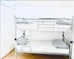 a bunk bed with white bunk beds in a room at A.G ROMANA HOSTEL in Bucharest