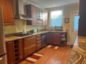 cocina con armarios de madera y horno con fogones en 3 Level 4 Bedroom Home w/ Parking in Adams Morgan en Washington