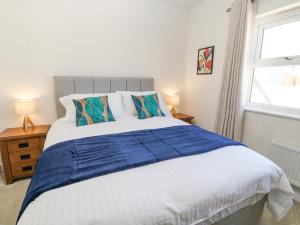 Un dormitorio con una cama grande y una ventana. en Meadow Bay, en Bideford