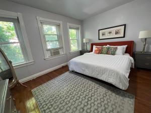 1 dormitorio con 1 cama, 2 ventanas y alfombra en 3 Level 4 Bedroom Home w/ Parking in Adams Morgan en Washington