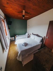 una camera da letto con due letti e soffitto in legno di Pouso do Carteiro a Tiradentes