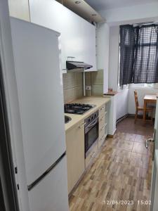 eine Küche mit einem Herd oberer Ofen neben einem Tisch in der Unterkunft Fabian central apartment in Bukarest