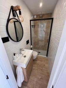 uma casa de banho com um lavatório, um chuveiro e um espelho. em La Noria32 em Nerja