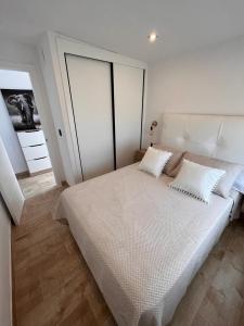 um quarto com uma grande cama branca e 2 almofadas em La Noria32 em Nerja