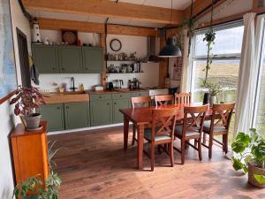 kuchnia z zielonymi szafkami oraz drewnianym stołem i krzesłami w obiekcie Rustic Farmhouse - Narfasel w mieście Akranes