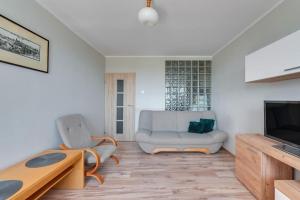 a living room with a couch and a television at Motława 2 by Grand Apartments in Gdańsk