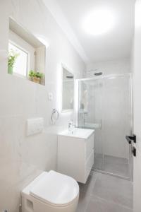 a white bathroom with a toilet and a shower at Villa Matea in Nin
