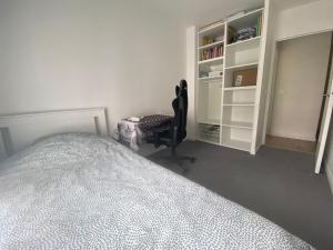 una camera con letto, scrivania e sedia di Logement spacieux avec chambre privée a Noisy-le-Grand