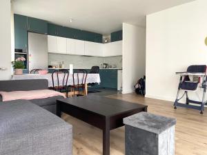 un soggiorno con divano e tavolo di Logement spacieux avec chambre privée a Noisy-le-Grand