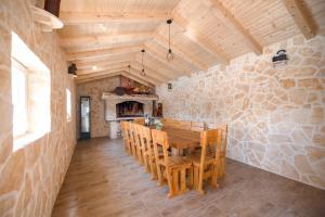 a dining room with a wooden table and a stone wall at Villa Matea in Nin