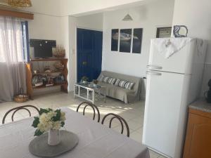 een keuken en een woonkamer met een tafel en een koelkast bij Villa Konstantina in Kalymnos