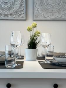 einen Tisch mit Weingläsern und eine Vase mit Blumen in der Unterkunft Goethe Palais Suite Charlotte 4P l Lift I Parkplatz in Aue